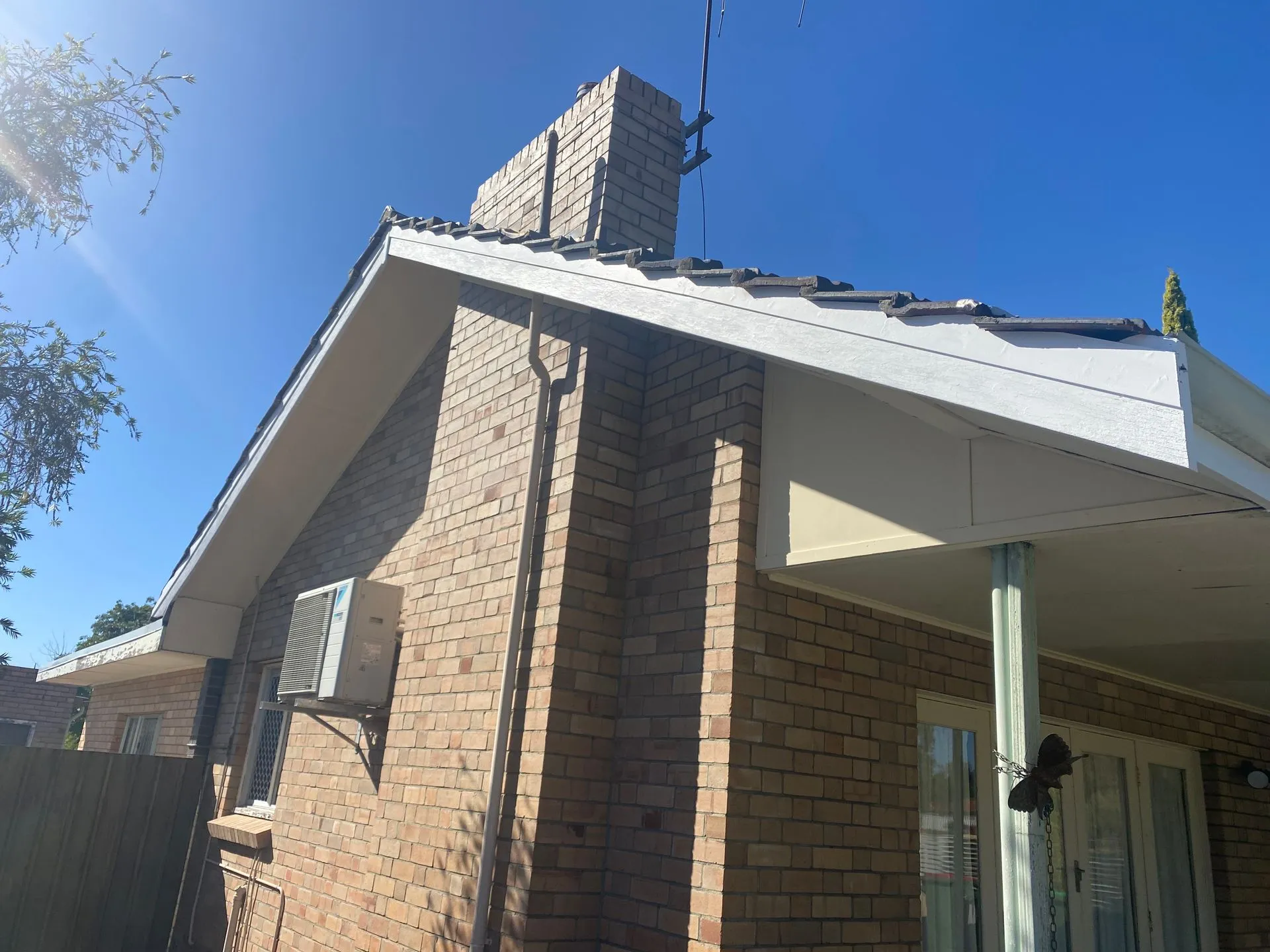 Brick house exterior with chimney and tiled roof