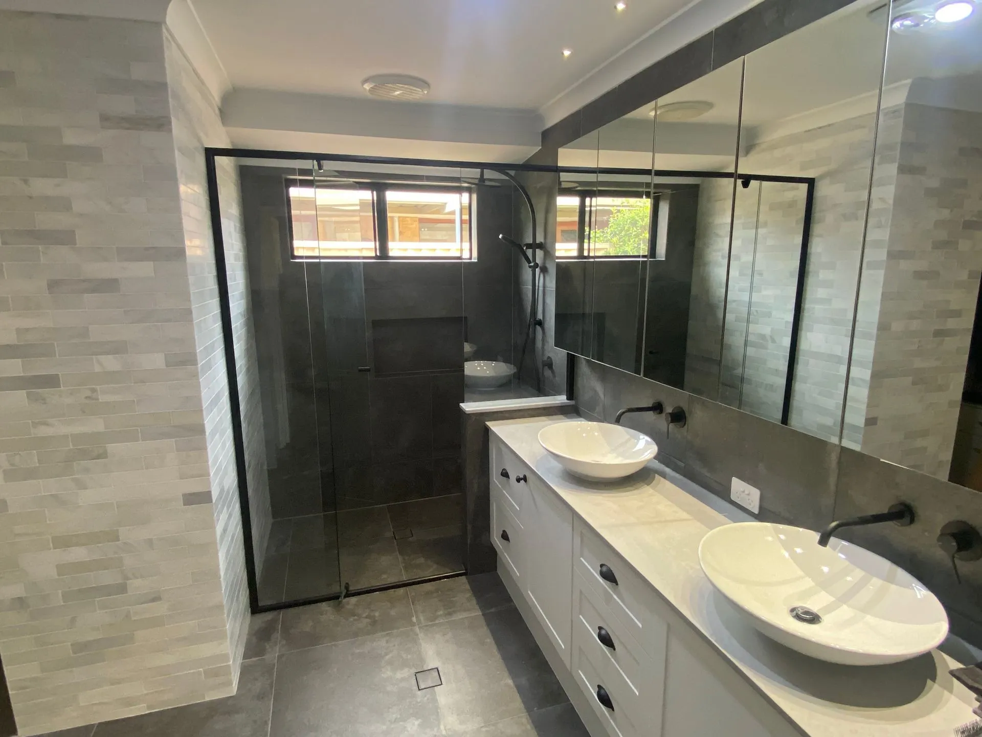 Modern ensuite with double floor-mounted vanity and glass shower