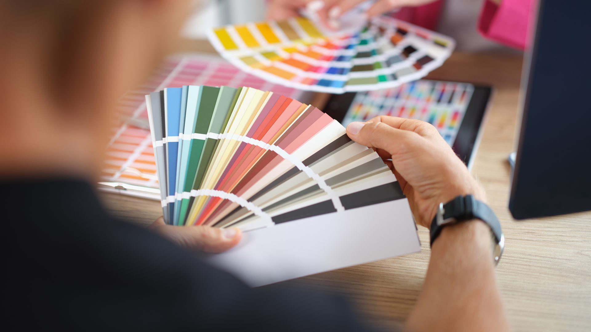 Person holding colour swatches choosing paint samples for a Perth home