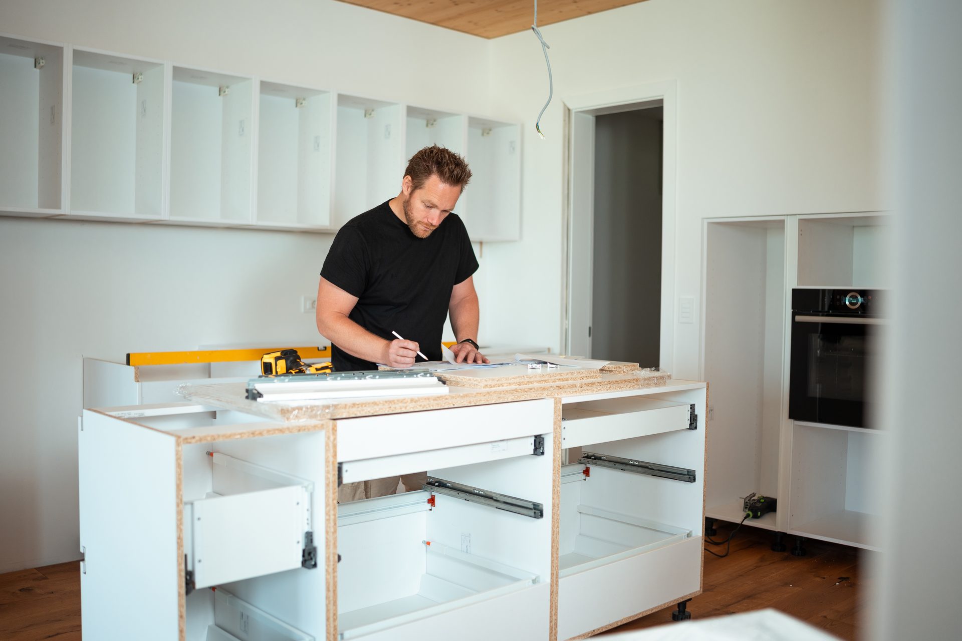Tradesman installing quality hardware during kitchen cabinet assembly