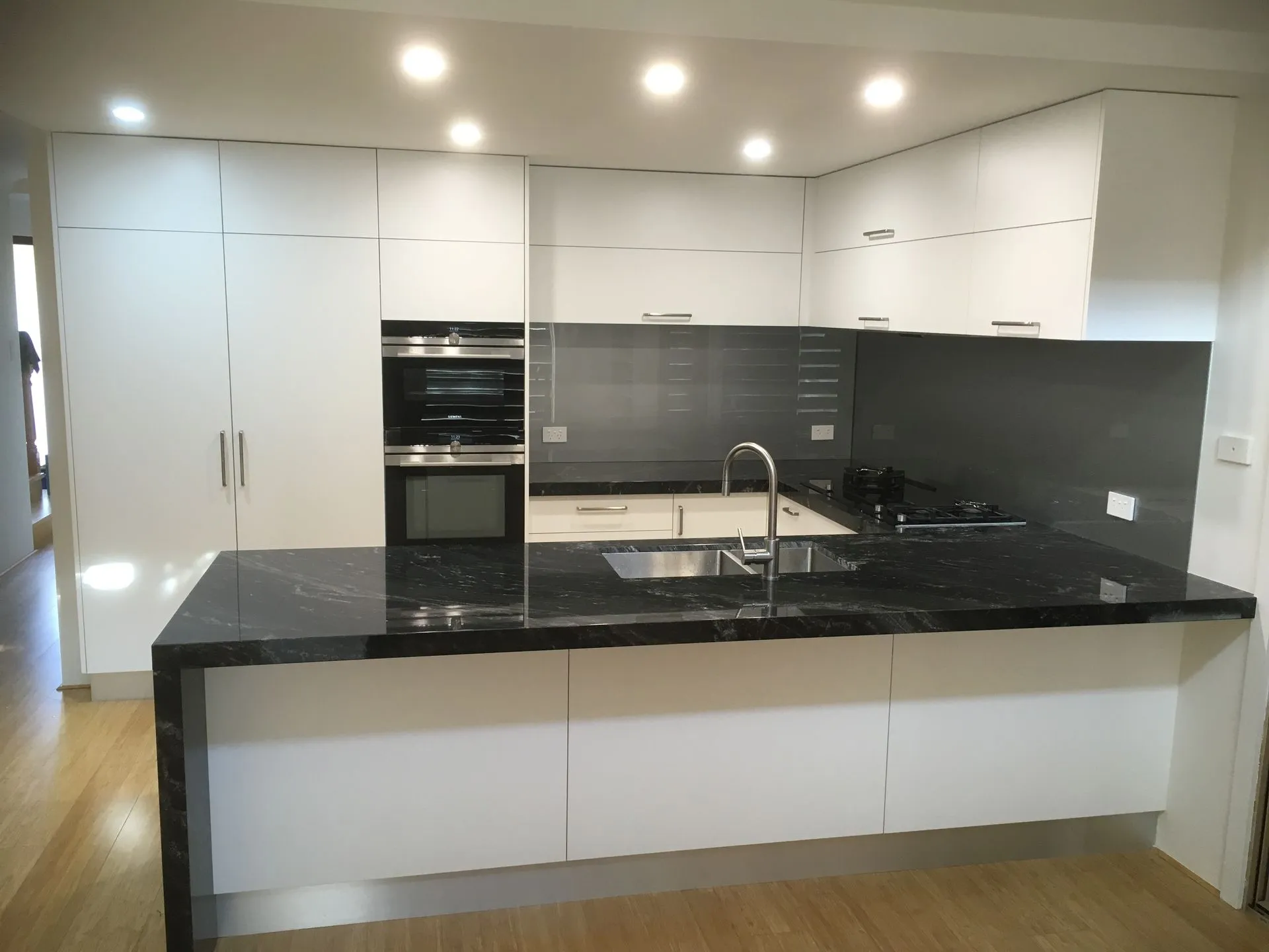 Modern white kitchen renovation with stone island benchtop in Perth