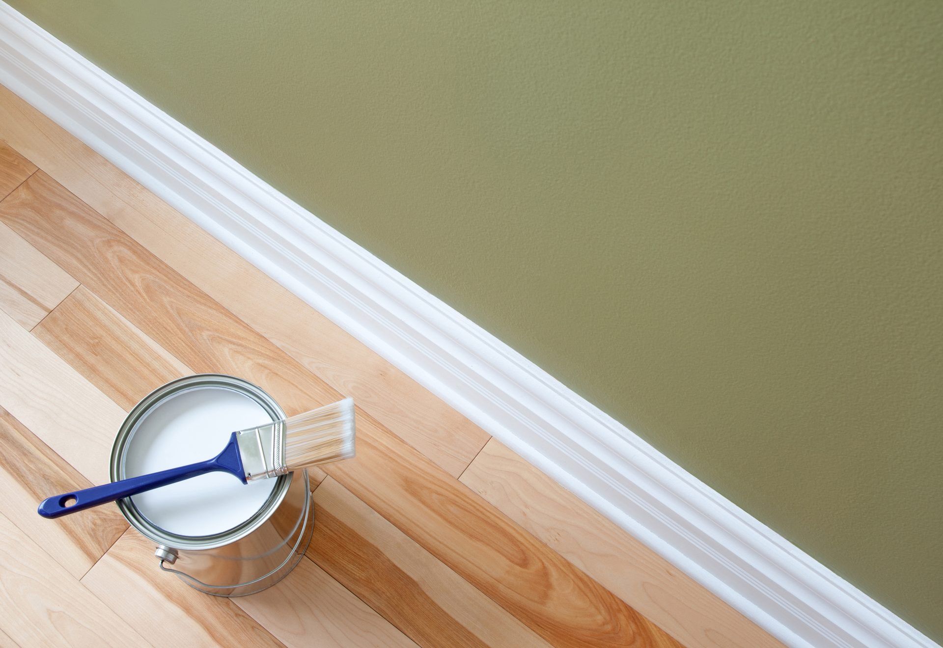 Paint tin and brush on wooden floor prepared for interior painting