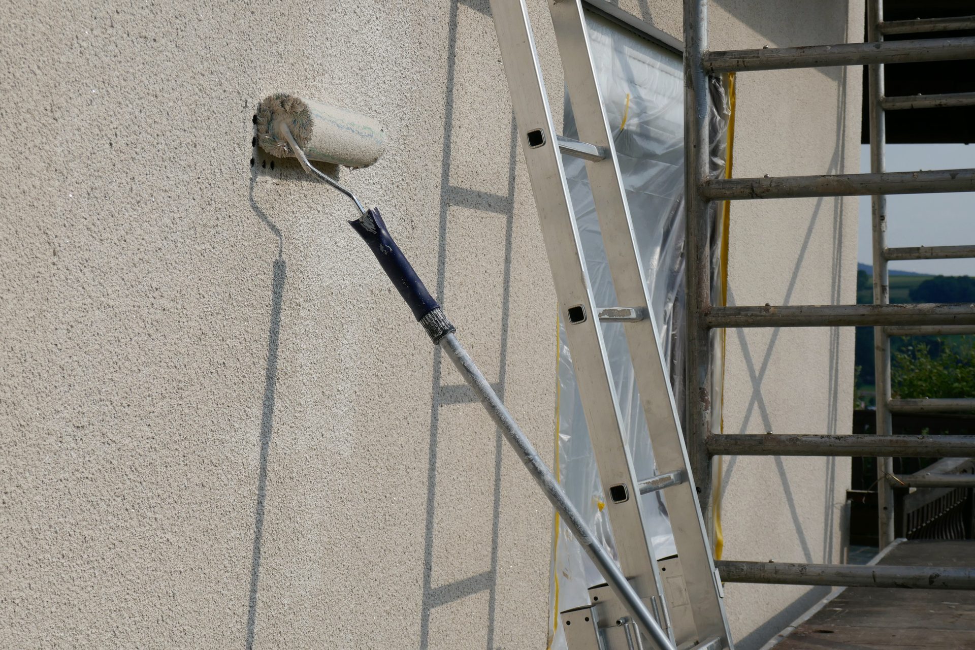 Exterior painting preparation with roller and ladder access