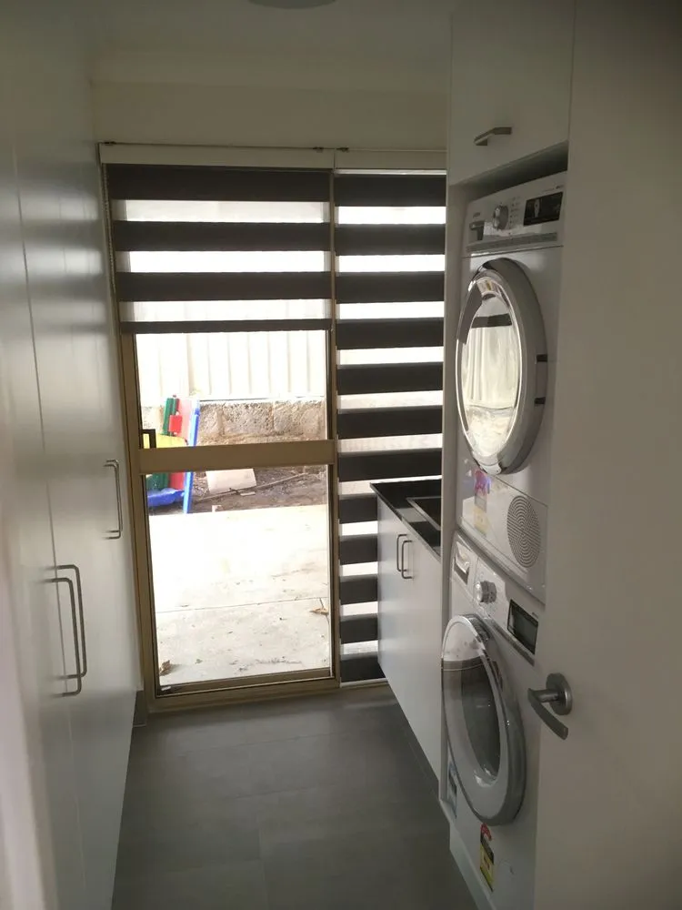 Compact galley laundry with stacked washer and dryer in a Perth home